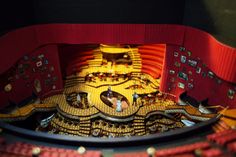 an overhead view of a theatre with red seats and yellow walls, looking down at the stage