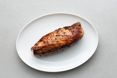 a piece of meat sitting on top of a white plate