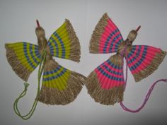 three small handmade fan shaped kites hanging on a wall