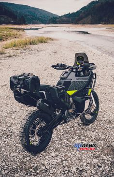 a motorcycle parked on the side of a gravel road