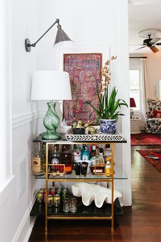 a living room filled with lots of furniture and decor on top of a wooden floor