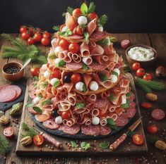 a very unusual looking cake made out of meats and vegetables on a wooden table