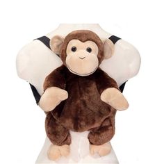 a stuffed monkey sitting on top of a white chair with its arms in the air