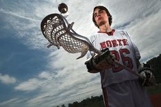 a young man holding a lacrosse ball in his hands