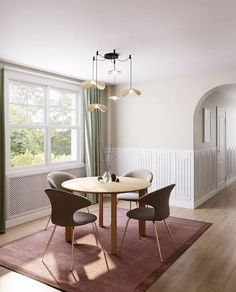 a dining room table with chairs and a rug on the floor in front of it