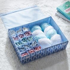 a blue box filled with lots of different types of baby items next to a book