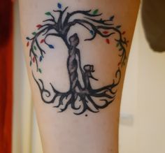 a tattoo on the leg of a woman with an image of a man and tree