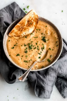 a bowl filled with soup and two pieces of bread