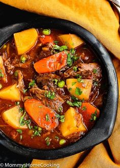 a pot filled with stew and vegetables on top of a table