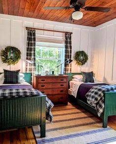 two beds in a room with wooden ceilings and plaid blankets on top of them, next to each other