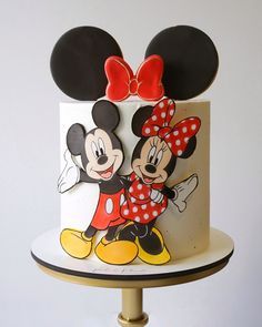 a mickey and minnie mouse cake on a stand