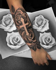 a man's arm with roses and a cross on it