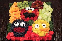 a platter filled with cut up fruits and veggies to look like sesame the movie characters