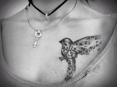 a woman's chest with a bird and cross tattoo on it