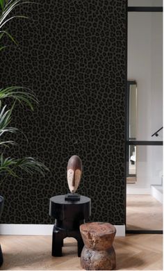 an animal print wallpaper in a living room with two stools and a potted plant