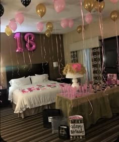 balloons and streamers are hanging from the ceiling above a bed in a hotel room