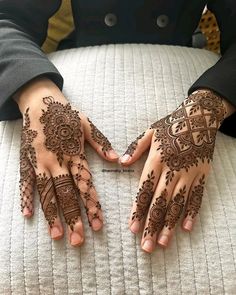 two hands with henna tattoos on them