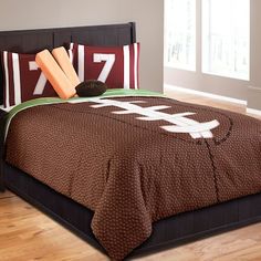 a bed with brown and white bedspread, pillows and pillow cases on it