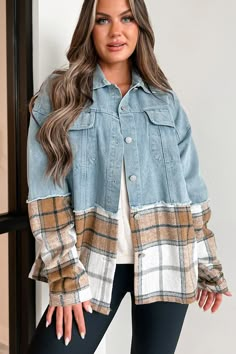 a woman standing in front of a window wearing a jean jacket and leggings