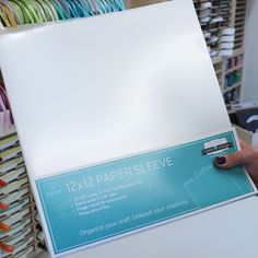 a person holding up a piece of paper in front of a rack with other items