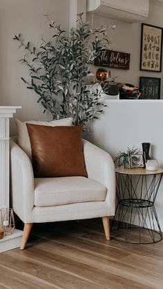 a white chair sitting next to a fireplace with a potted plant on top of it