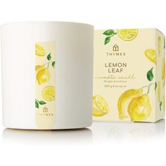 a white mug with lemon leaves on it next to a box