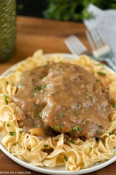 a white plate topped with pasta covered in gravy