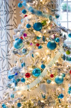 a white christmas tree with blue and red ornaments