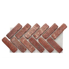 several pieces of red brick laid out on a white surface, with one piece missing from the