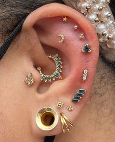 an ear with different types of piercings attached to it's sides and on the side