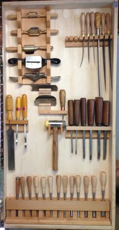 a wall mounted tool rack filled with lots of woodworking tools and wooden spoons