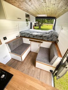 the interior of a camper with a bed and couch