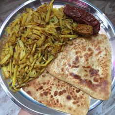 a silver plate topped with flatbreads and veggies next to other foods