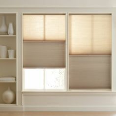 an empty room with white shelves and beige shades on the windows blinds in the window