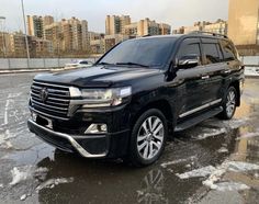 a black toyota land cruiser is parked in the parking lot with snow on the ground