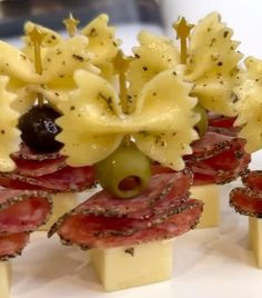 several appetizers are arranged on sticks with cheese and olives