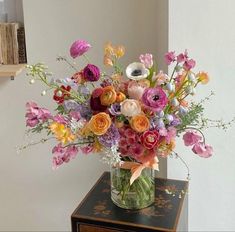 a vase filled with lots of different colored flowers