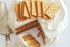 a cake and crackers on a plate with a knife next to it that has been cut in half