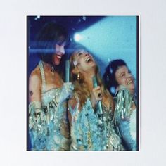 three women in sequins singing into microphones at a party poster - print