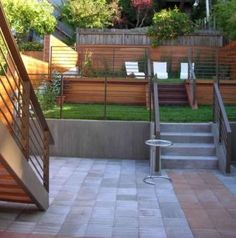 an outdoor patio area with stairs, seating and wooden fenced in areas around it