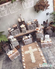 a table with candles and decorations on top of it in front of a cross rug