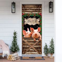 two pigs in front of a barn door with christmas wreaths on it and the words you're mine