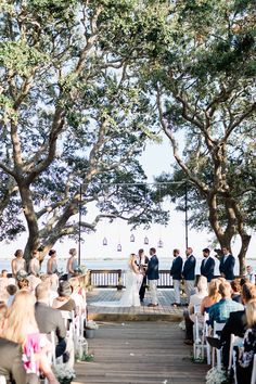 a bride and groom are getting married under the trees