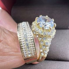 a person holding two rings in their hand, one with a large diamond on it