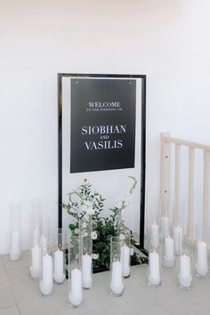 candles are lined up in front of a sign that reads, welcome to stobhan and vaslis