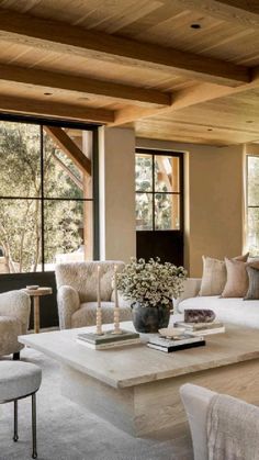 a living room filled with lots of furniture next to large window covered in wood planks