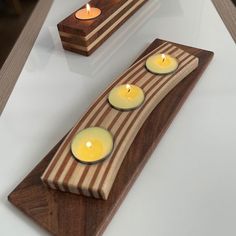 three candles are placed on a wooden plate