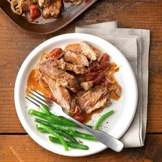 a white plate topped with meat and green beans