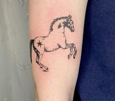 a black and white horse tattoo on the right arm, with stars in its mane