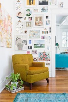 a yellow chair sitting on top of a hard wood floor next to a blue rug